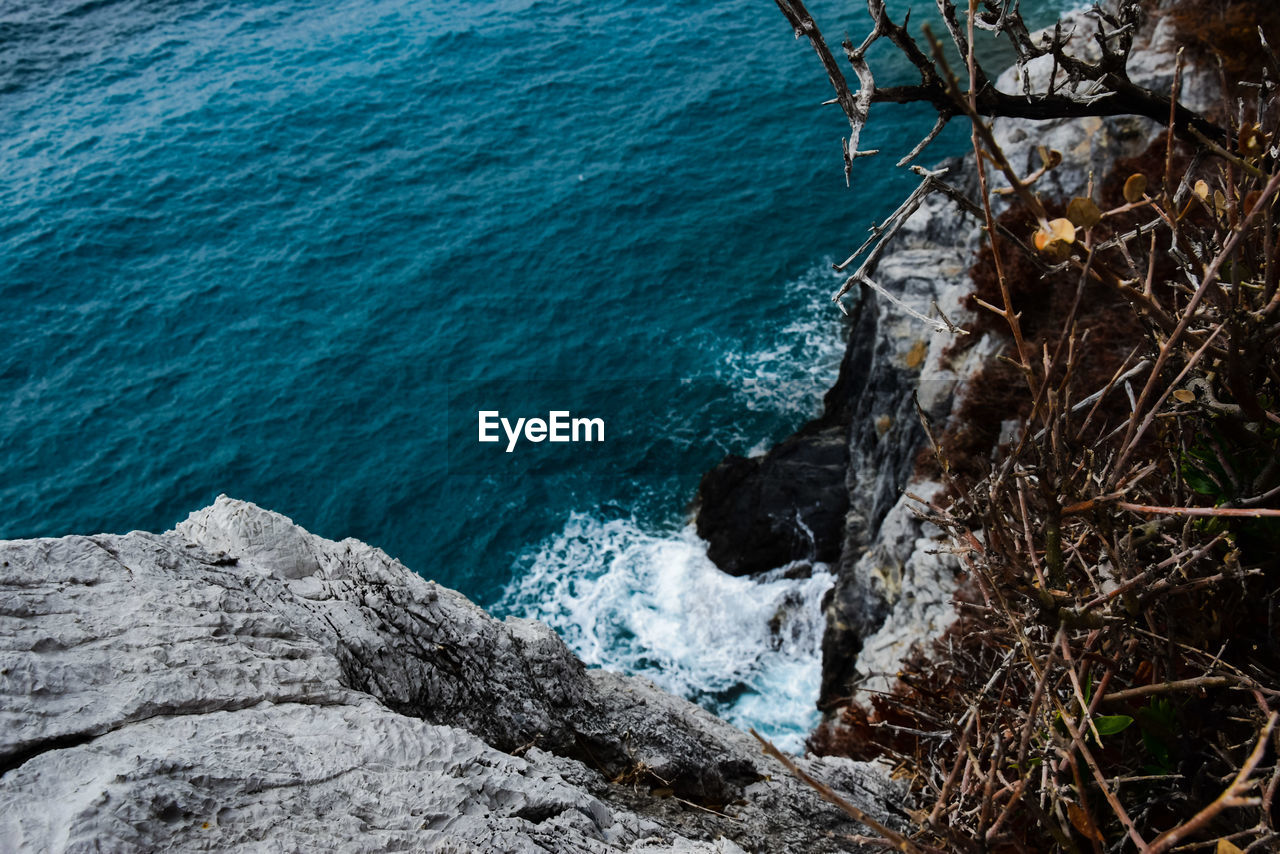 HIGH ANGLE VIEW OF ROCKS ON SHORE AT SEA