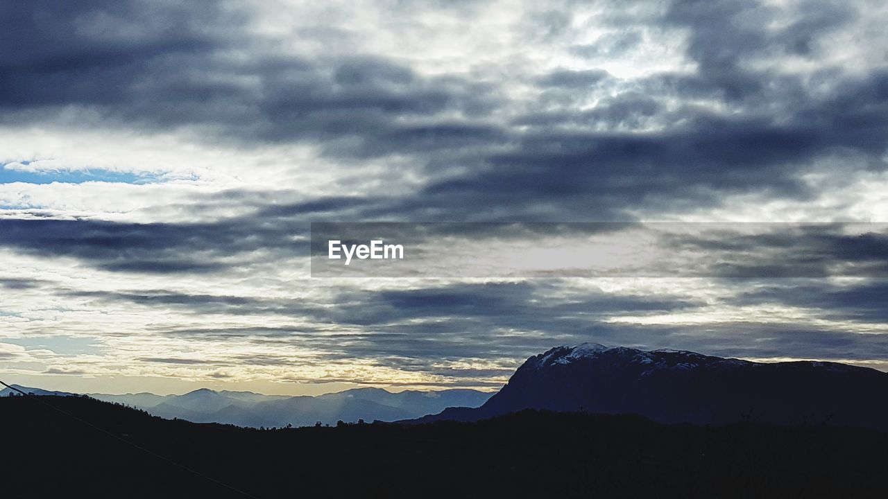 SCENIC VIEW OF DRAMATIC SKY OVER SILHOUETTE MOUNTAIN