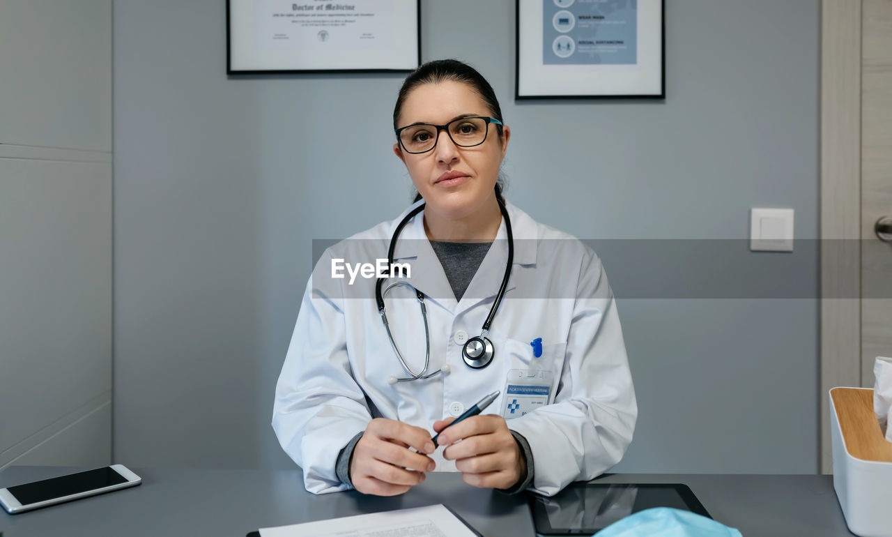 Female doctor looking at camera in her office