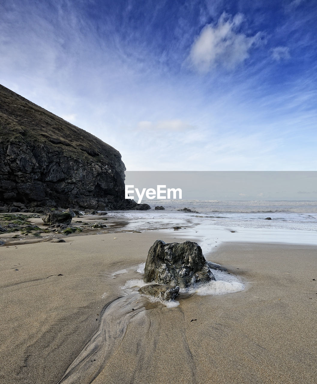 Rocks on beach against sky