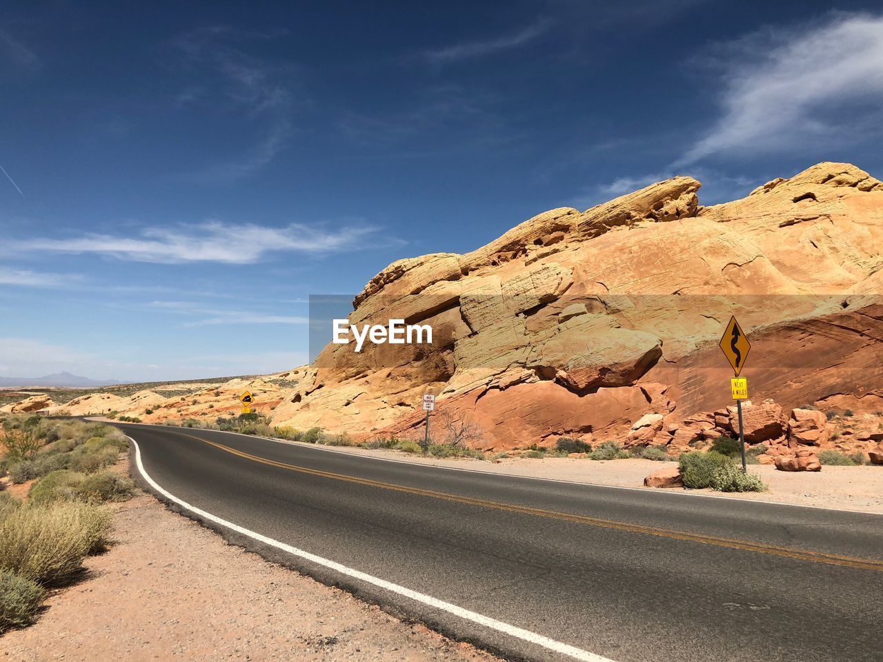 Road by rock formation against sky