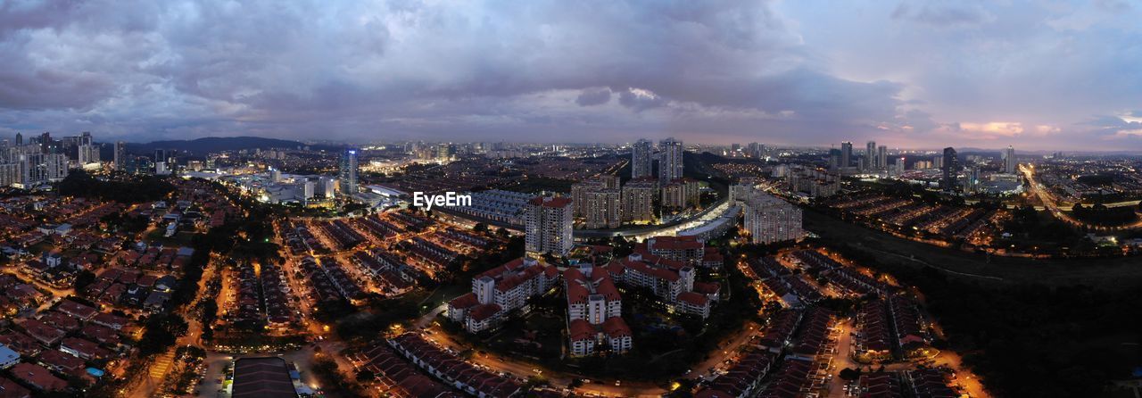 High angle view of city buildings against cloudy sky