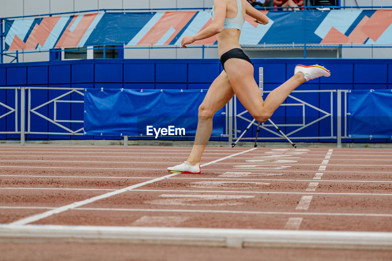 full length of young woman exercising on court