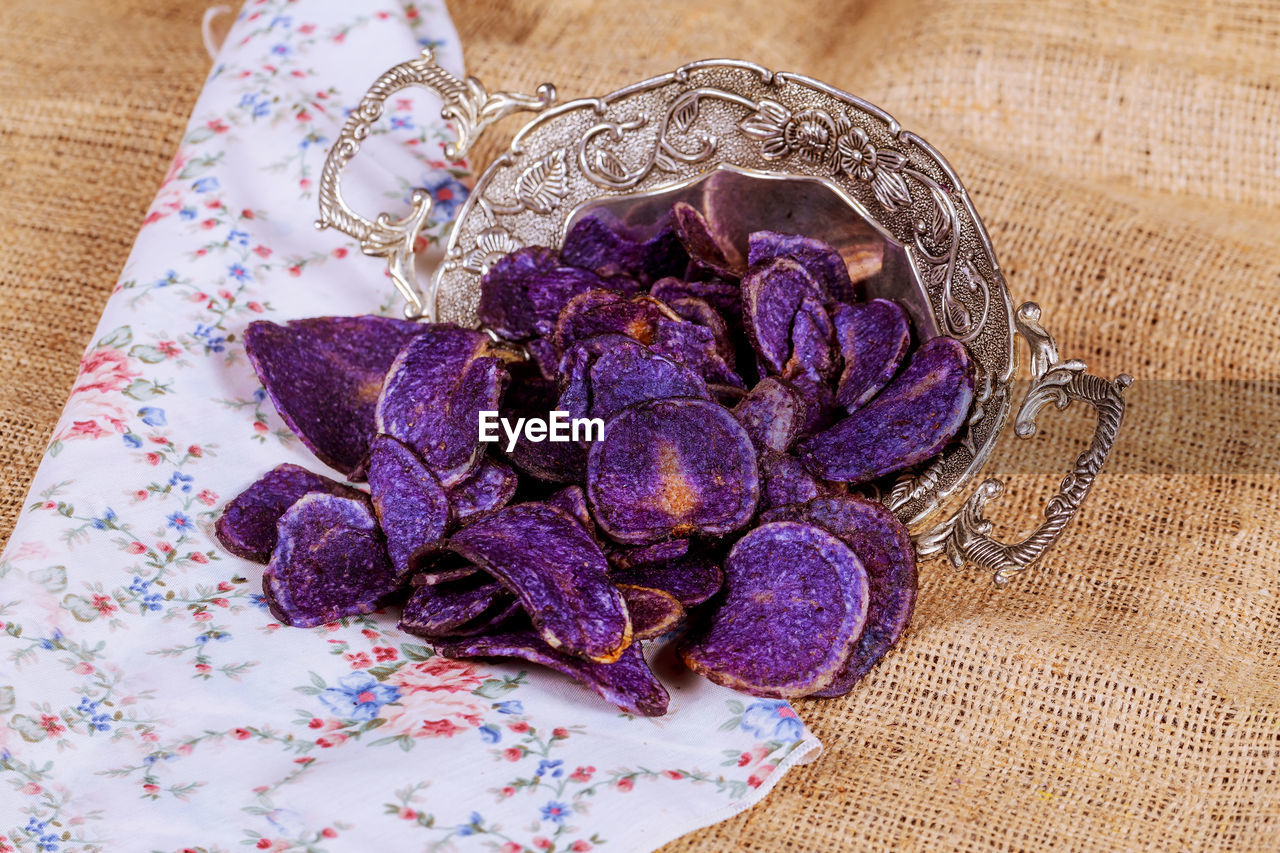 Close-up of fried chips in container on burlap