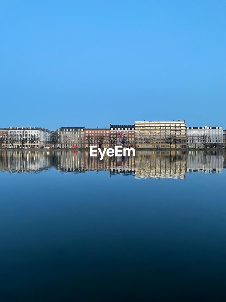 water, horizon, reflection, sky, sea, blue, architecture, clear sky, nature, built structure, dusk, copy space, no people, ocean, waterfront, building exterior, dock, skyline, day, coast, building, travel destinations, outdoors, morning, pier, cityscape, bay, tranquility, scenics - nature, beauty in nature, shore