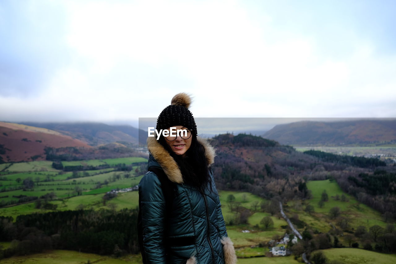 Portrait of woman standing against landscape during winter