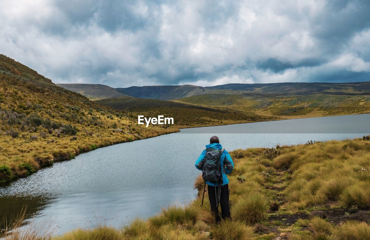 Rear view of a backpacker at lake ellis in chogoria route, mount kenya national park, kenya