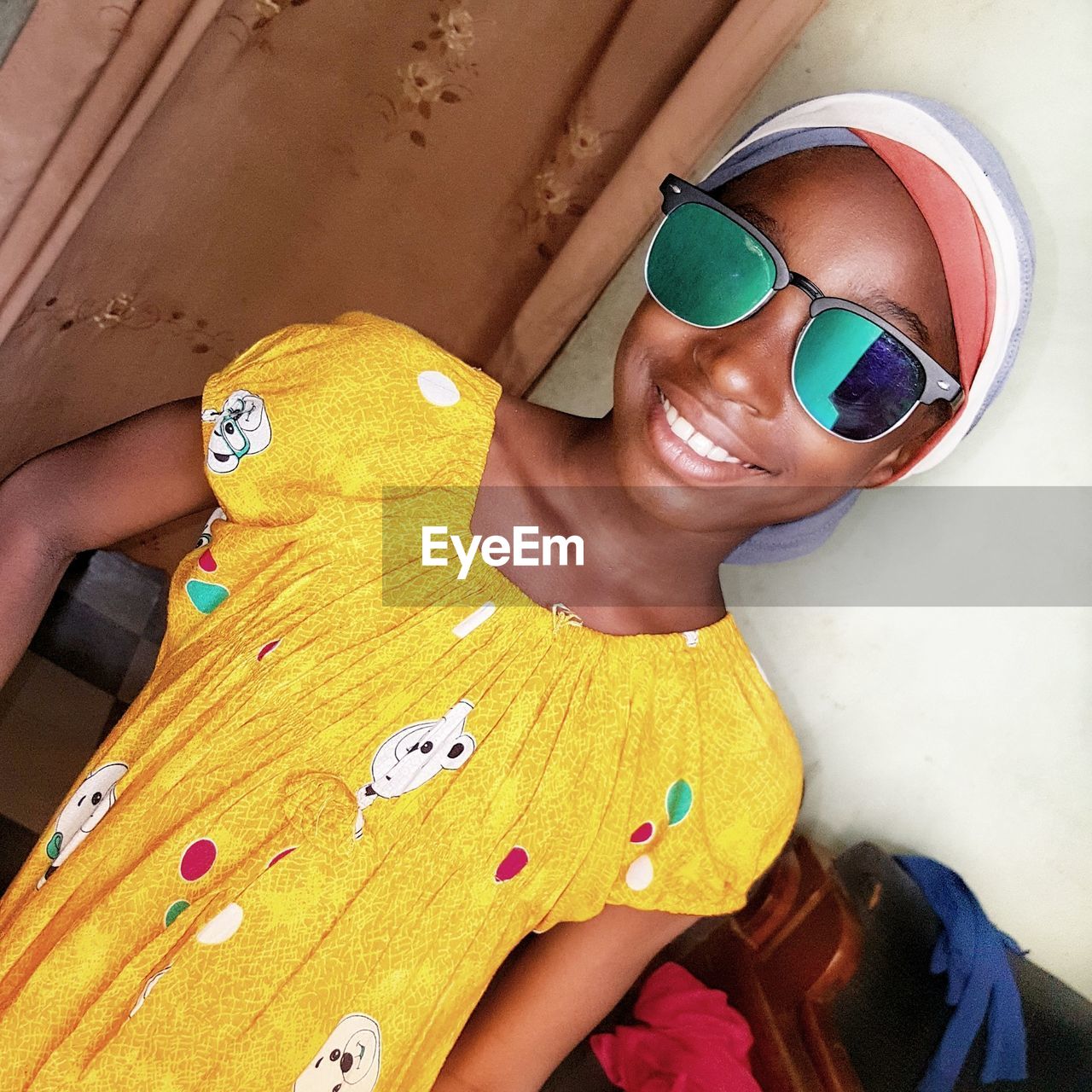 HIGH ANGLE PORTRAIT OF A SMILING YOUNG WOMAN WEARING SUNGLASSES