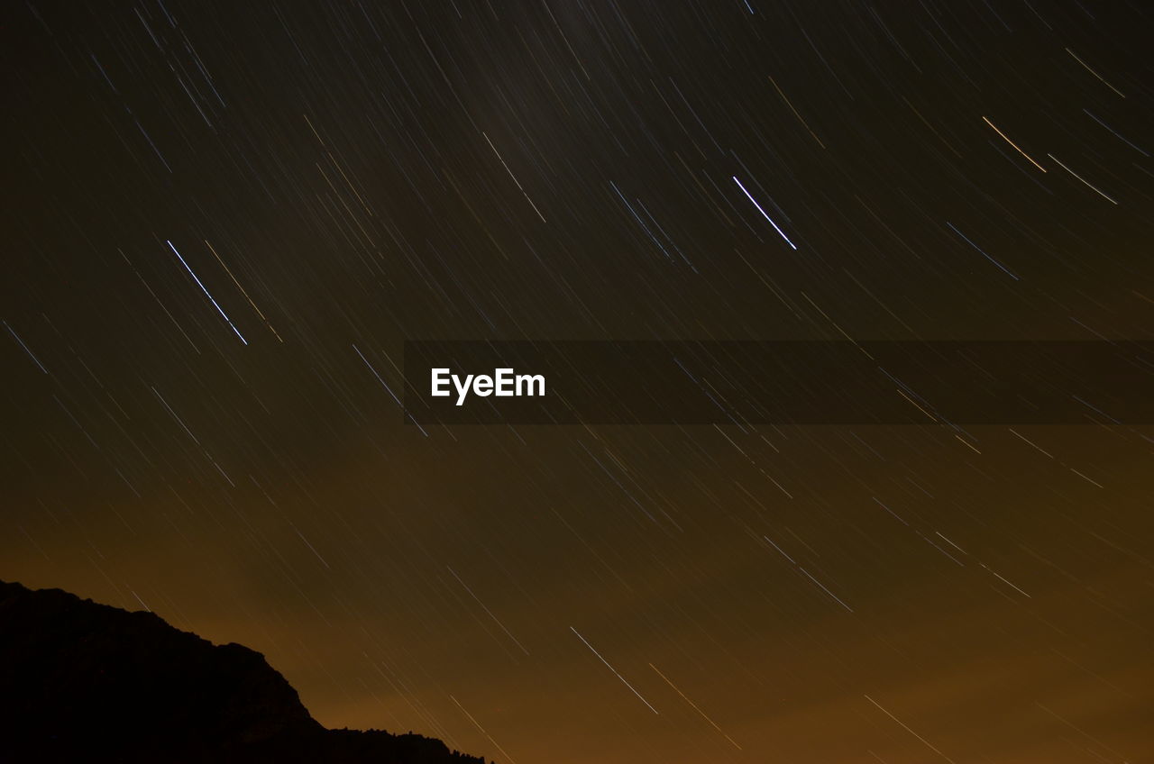 LOW ANGLE VIEW OF STAR TRAILS AT NIGHT