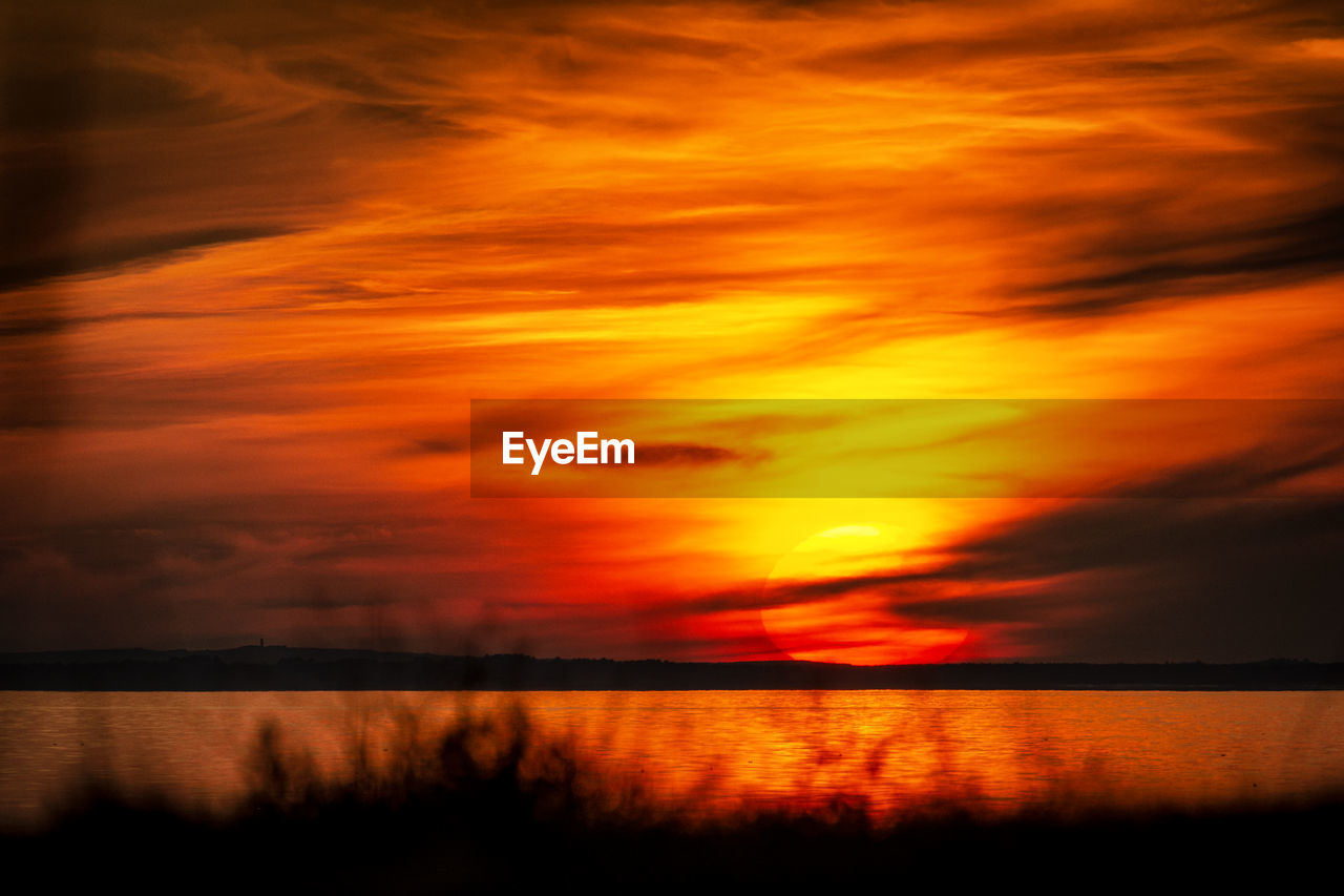 SCENIC VIEW OF DRAMATIC SKY OVER SEA DURING SUNSET