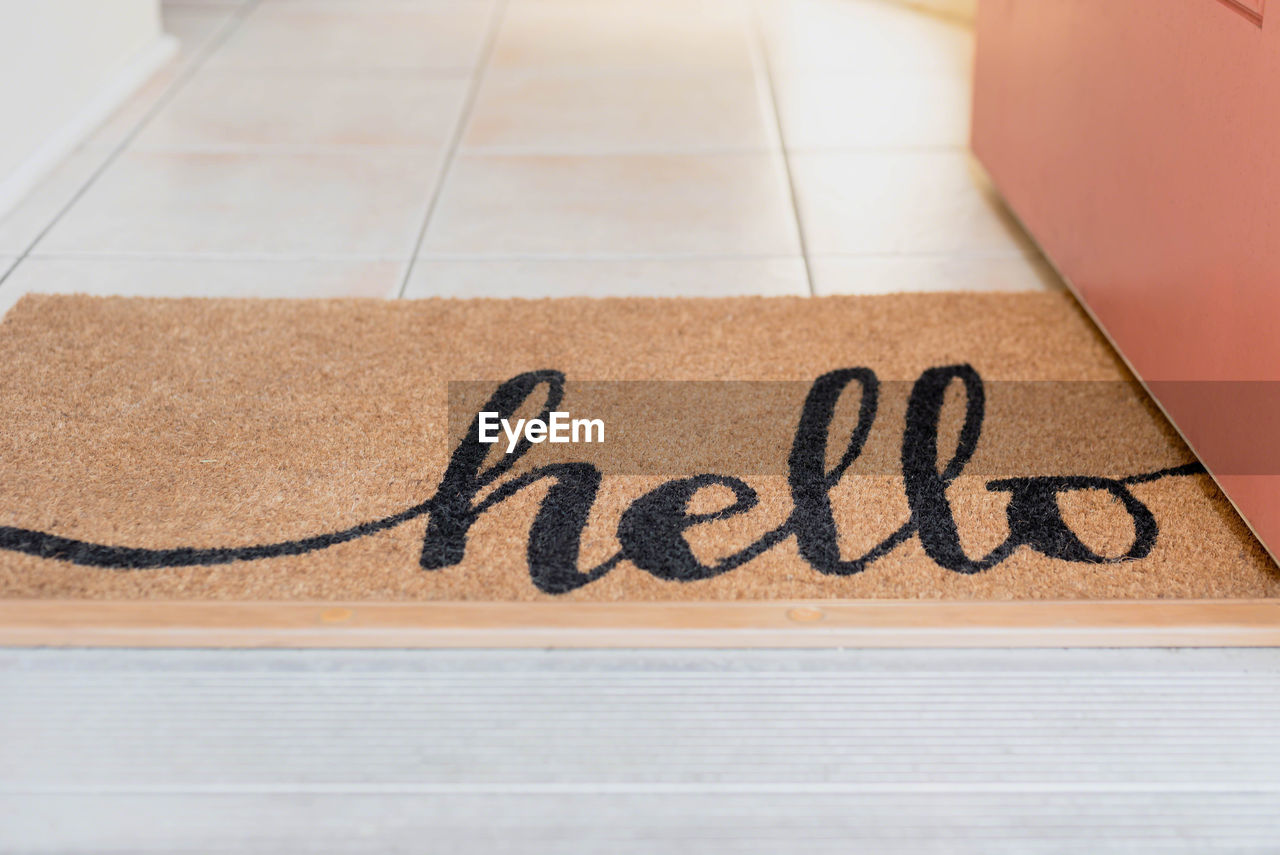 High angle view of hello text on doormat