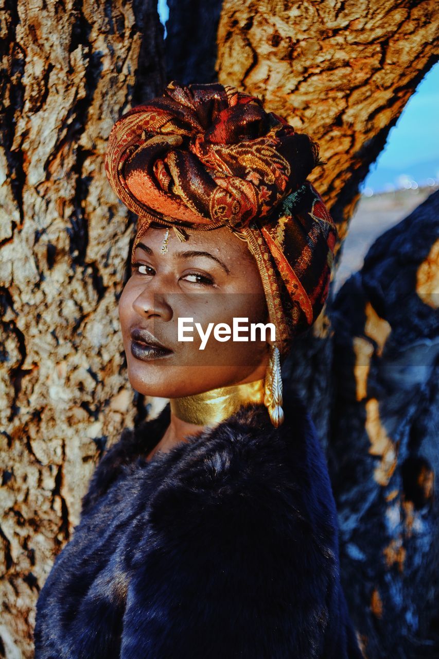 Close-up portrait of female model wearing traditional clothing by tree