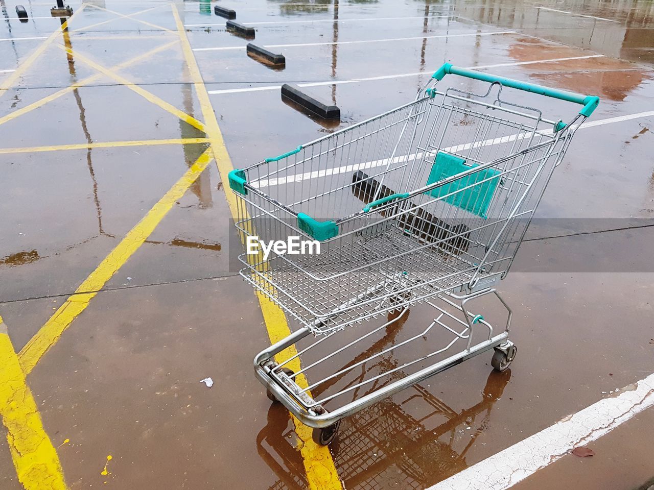 High angle view of empty shopping cart on wet footpath
