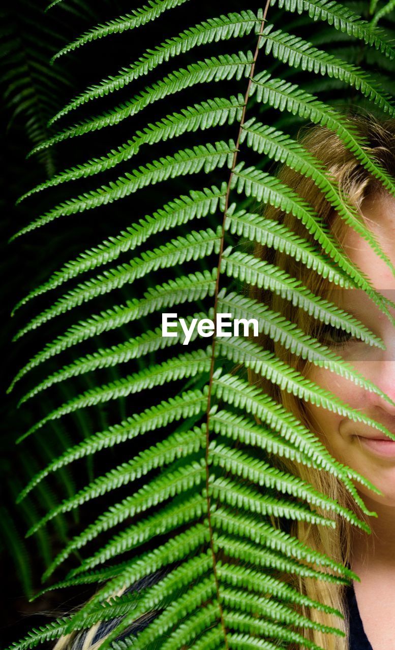 Portrait of woman seen through fern