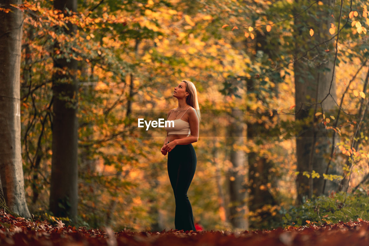 Full length of woman standing in forest