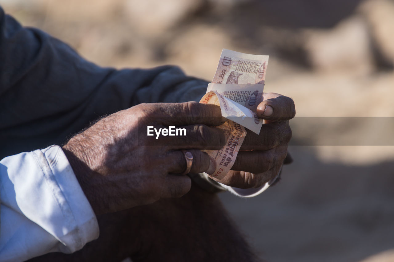 Close-up of man holding paper currency