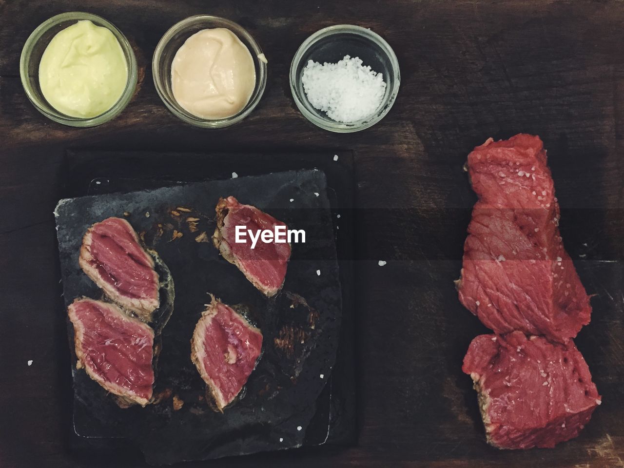 Directly above view of red meat with ingredients on table
