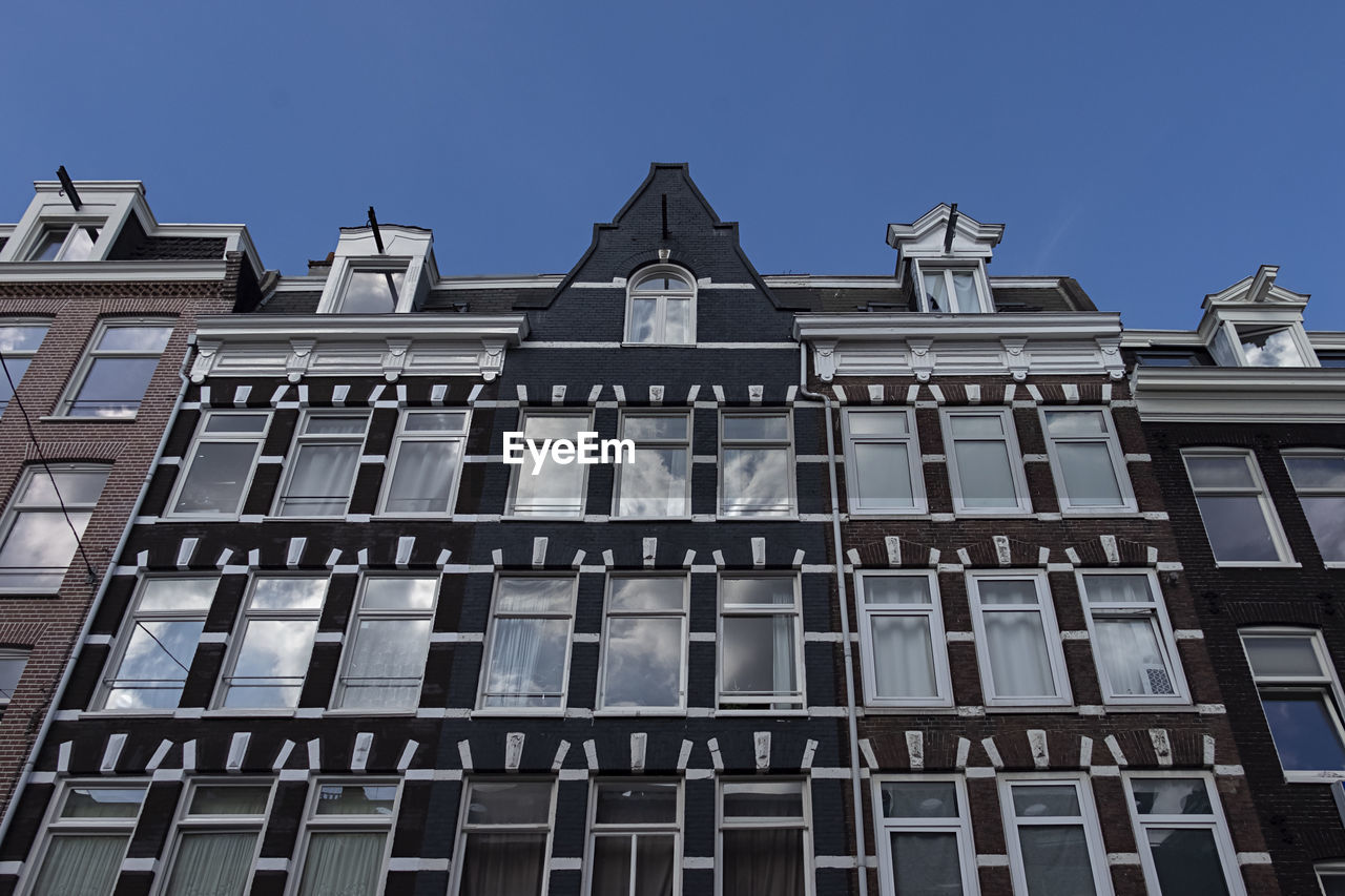 Low angle view of modern building against blue sky