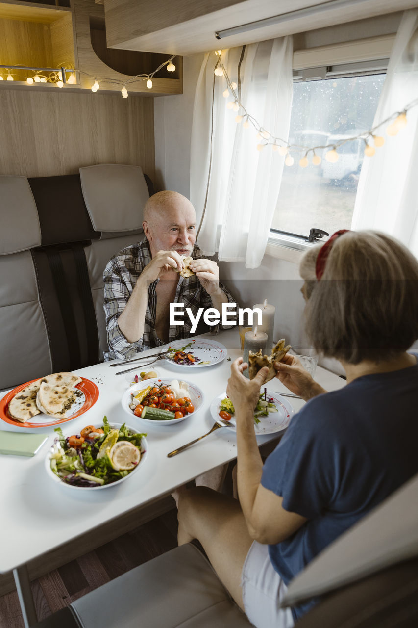 Retired senior couple eating lunch together in motor home