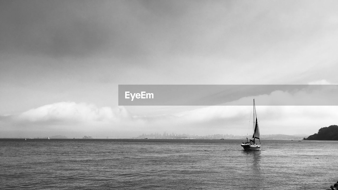 Sailboat sailing on sea against sky