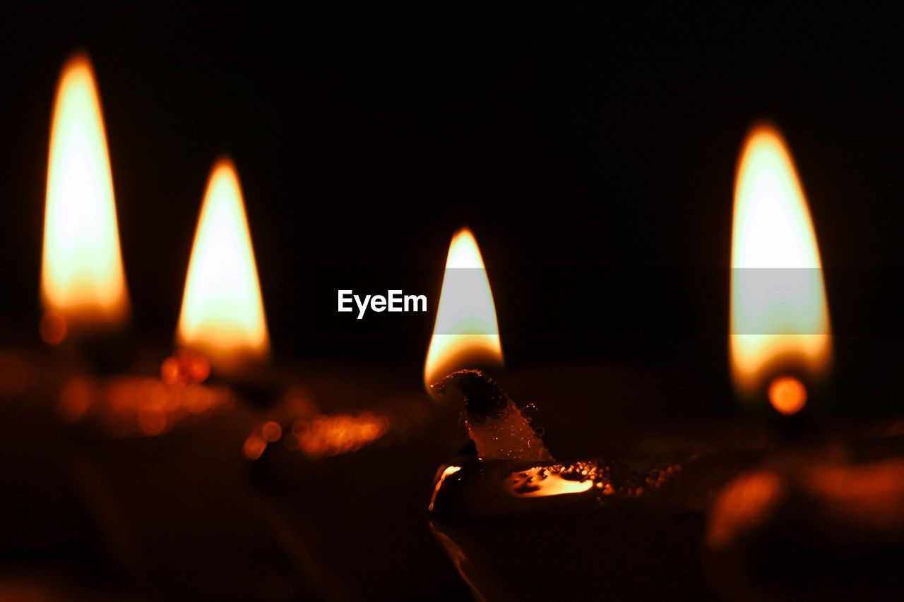 Close-up of lit candles in the dark