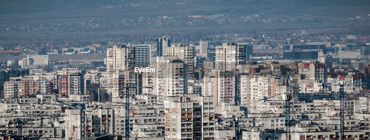 HIGH ANGLE VIEW OF BUILDINGS AGAINST CITY