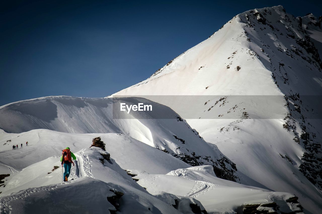 Rear view of man skiing on snow covered landscape