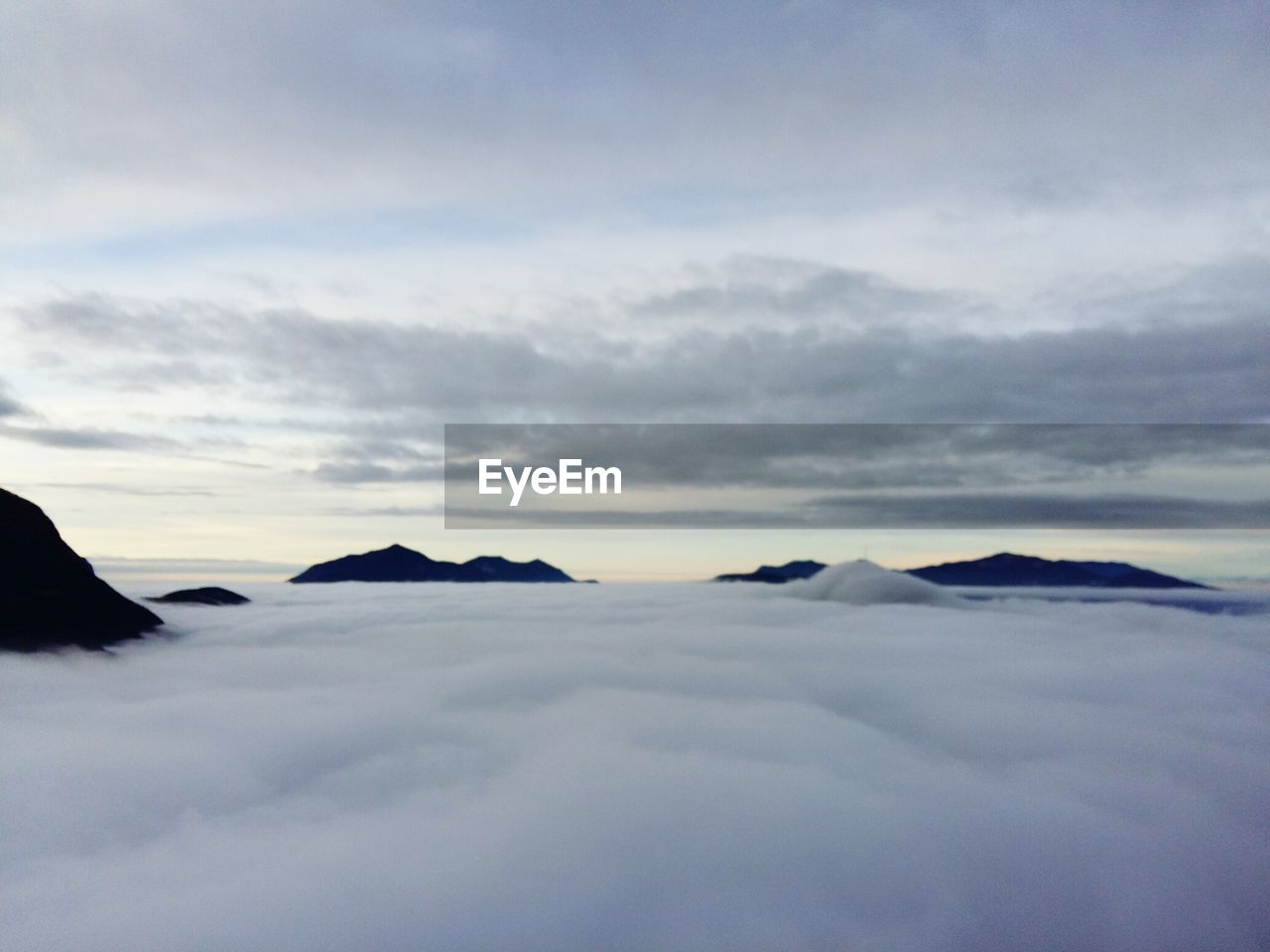 Scenic view of mountain tops peaking out of clouds