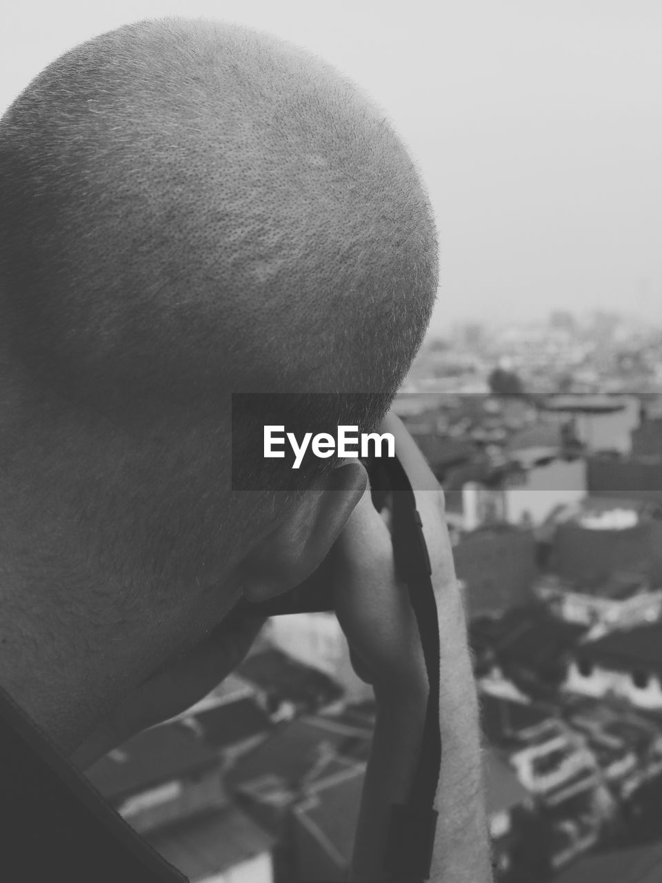 Man photographing through camera against sky