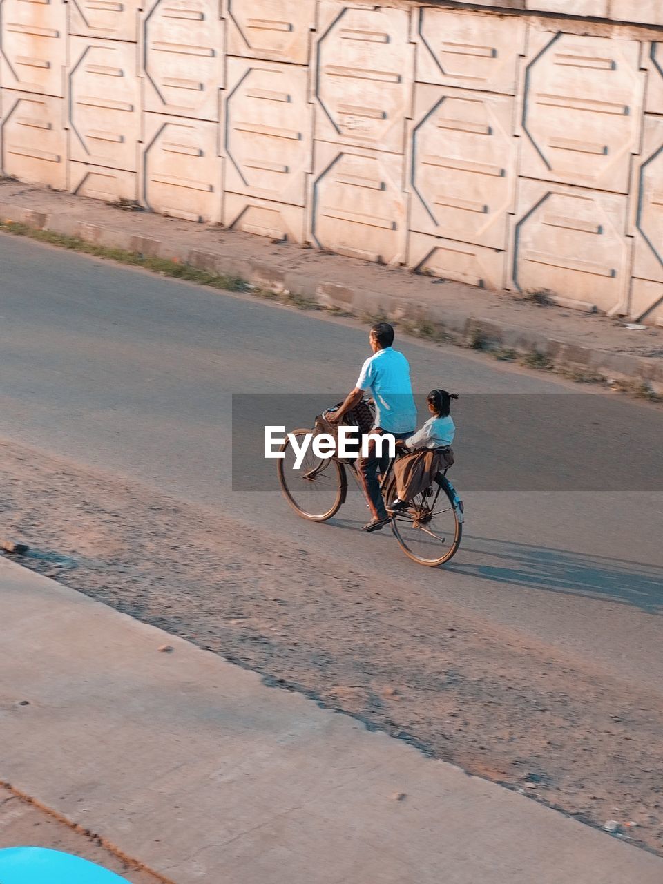 Rear view of man riding bicycle on street