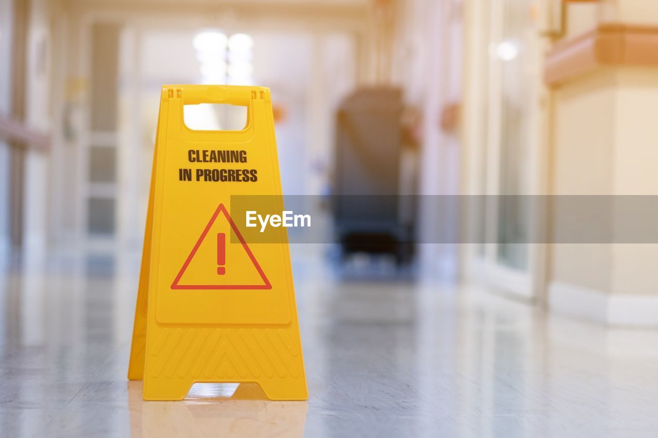 Close-up of yellow sign on floor