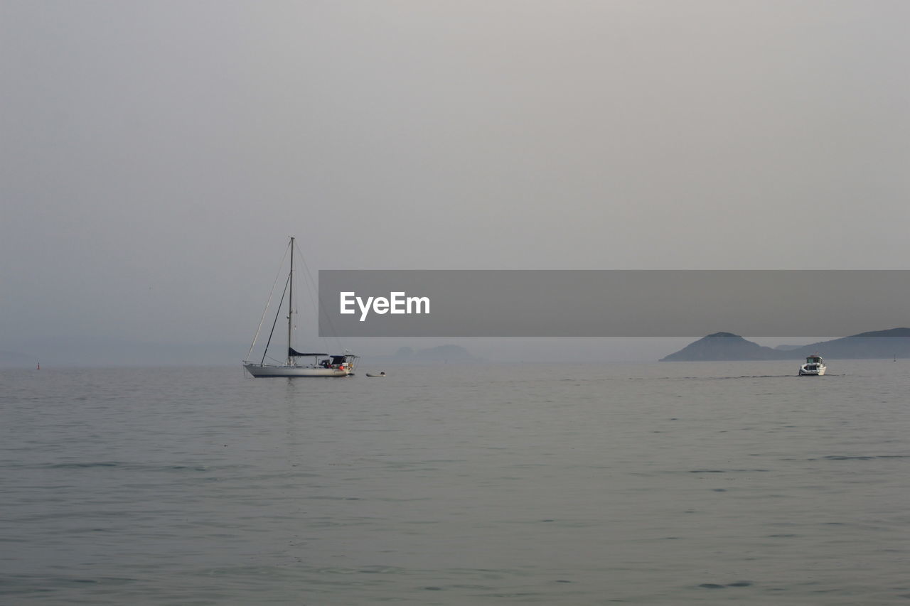 SAILBOATS SAILING ON SEA AGAINST CLEAR SKY