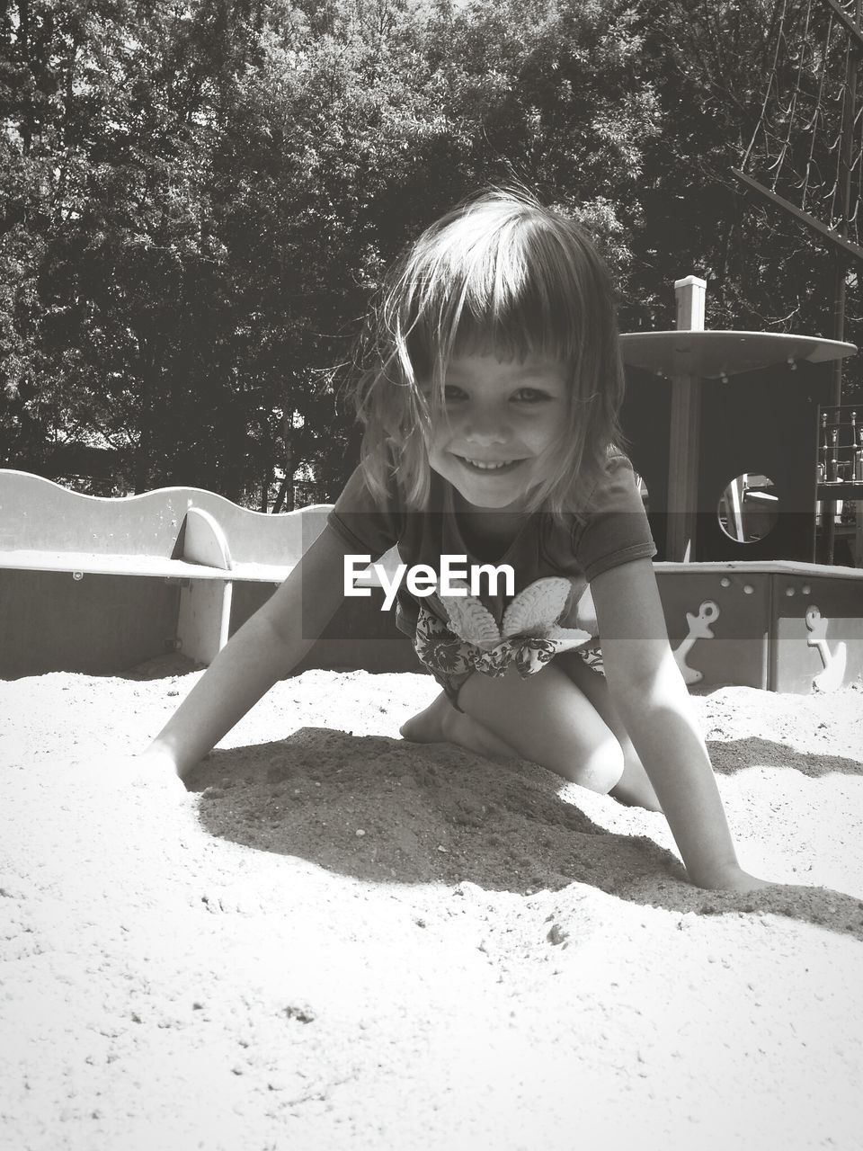 Portrait of cute girl playing in sandbox at playground