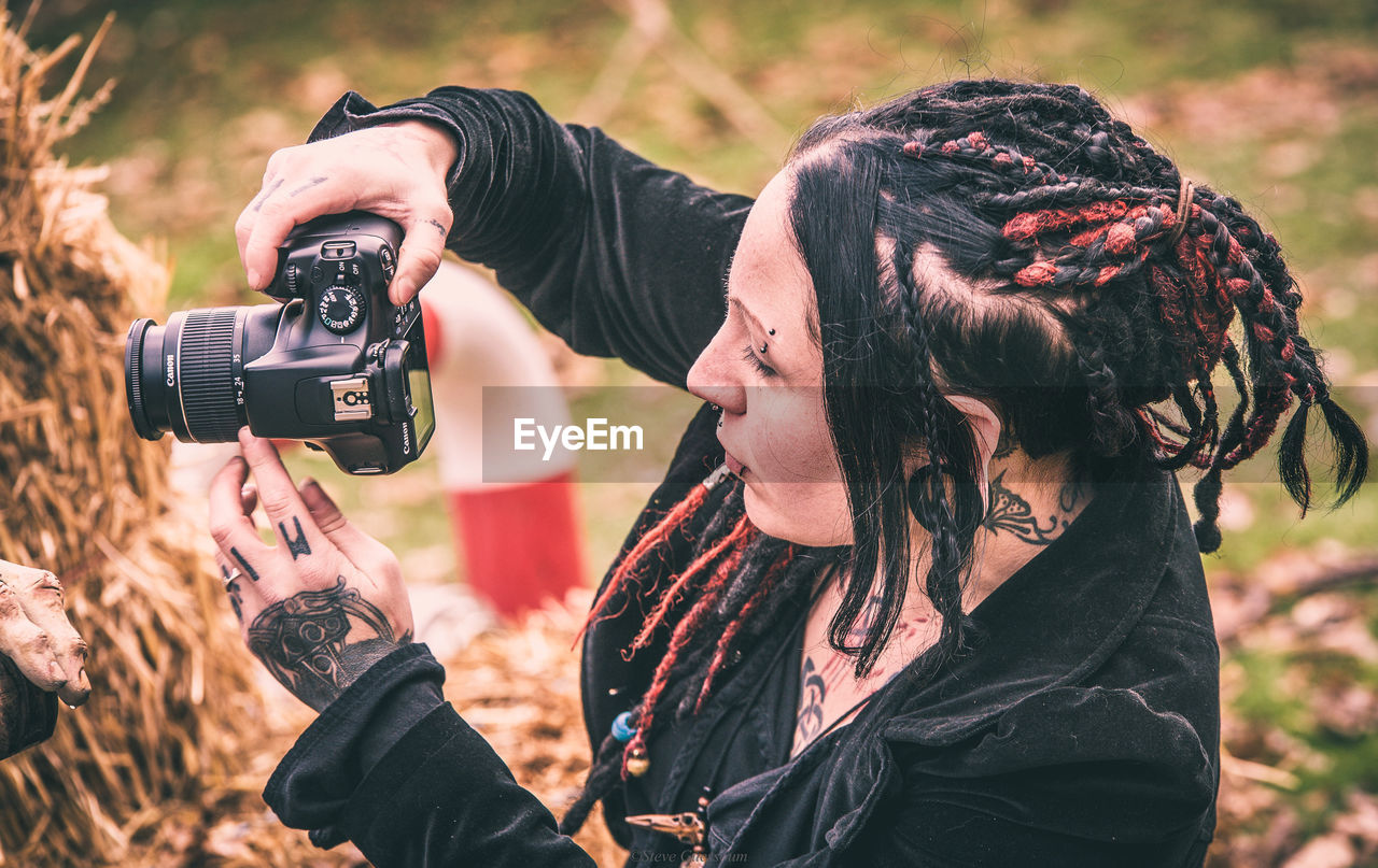 Close-up of mid adult woman photographing outdoors