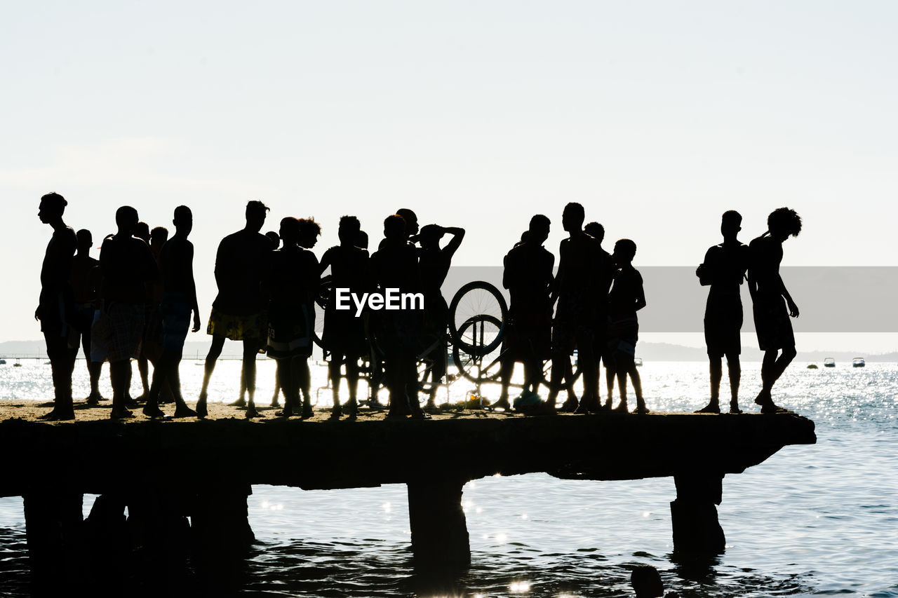 Dozens of young people, in silhouette, are seen during the sunset on top of the crush bridge 