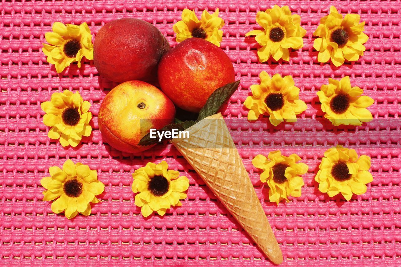 Directly above shot of apples and ice cream cone amidst artificial flowers
