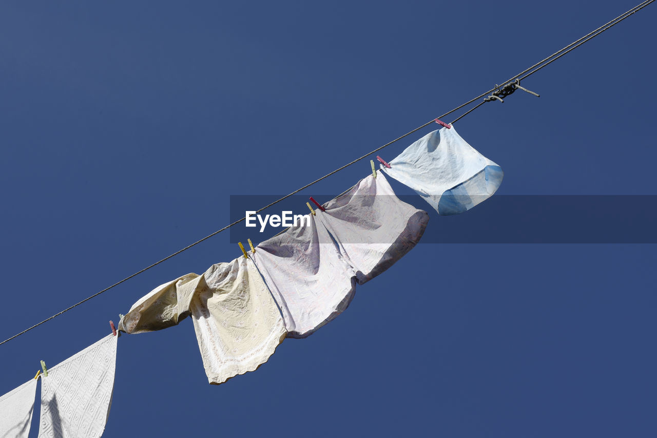 Clothes hanging and drying, in the wind, with a blue sky