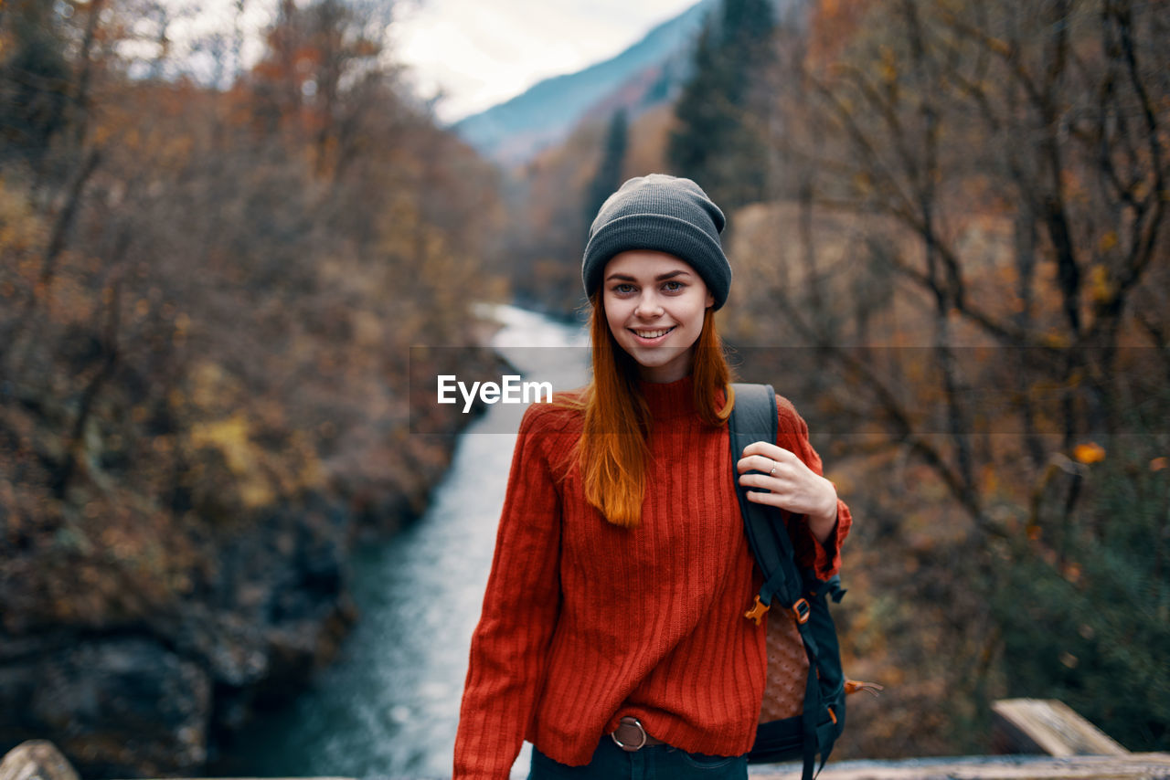 YOUNG WOMAN STANDING IN PARK