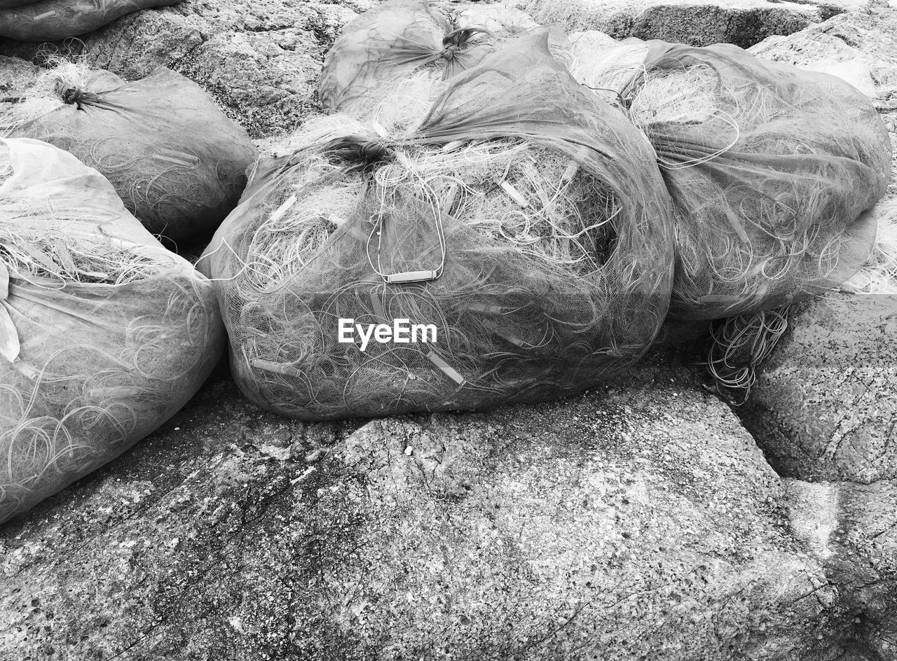 High angle view of fishing nets on stones at beach