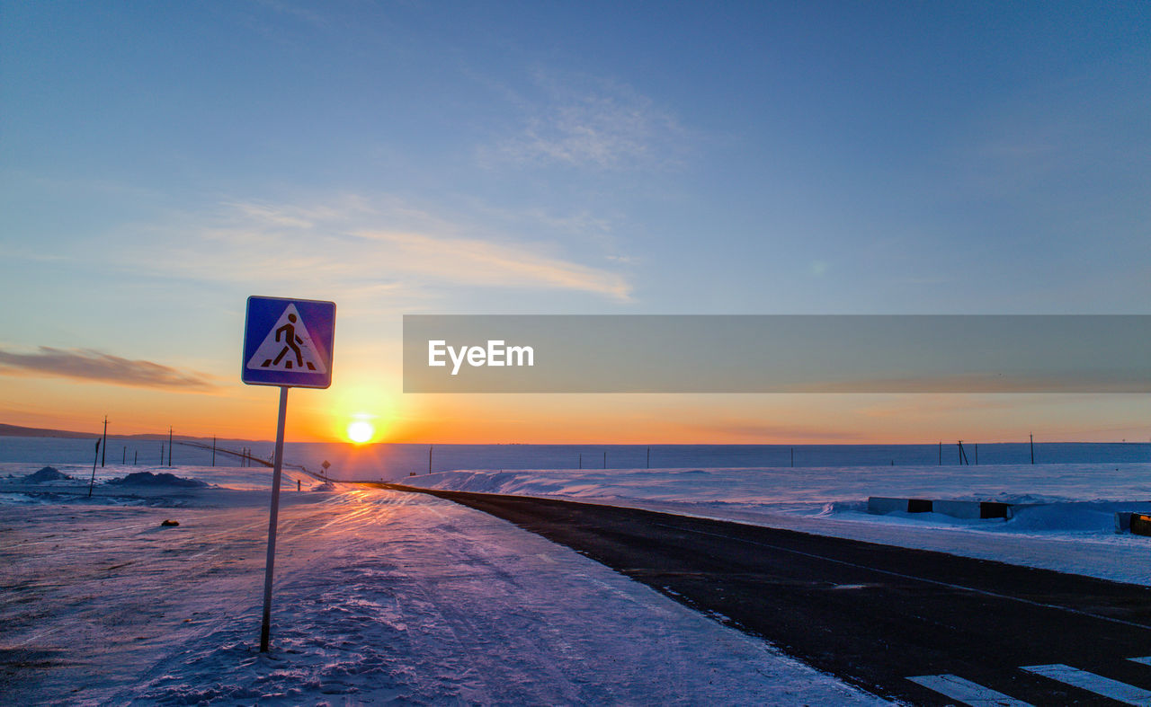 Empty road along snow covered landscape