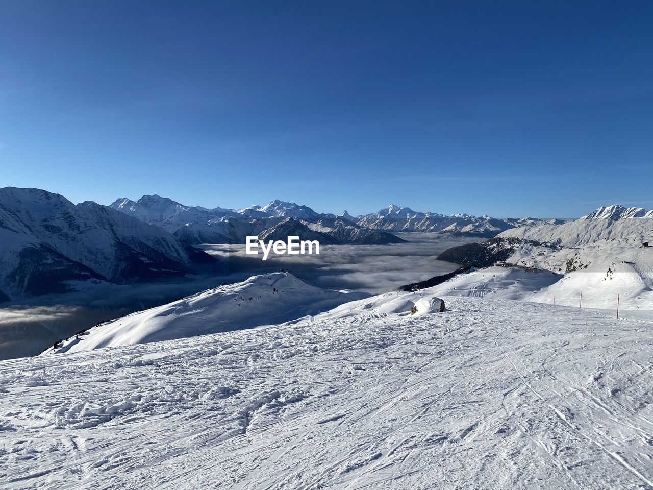 Scenic view of snowcapped mountains against clear blue sky