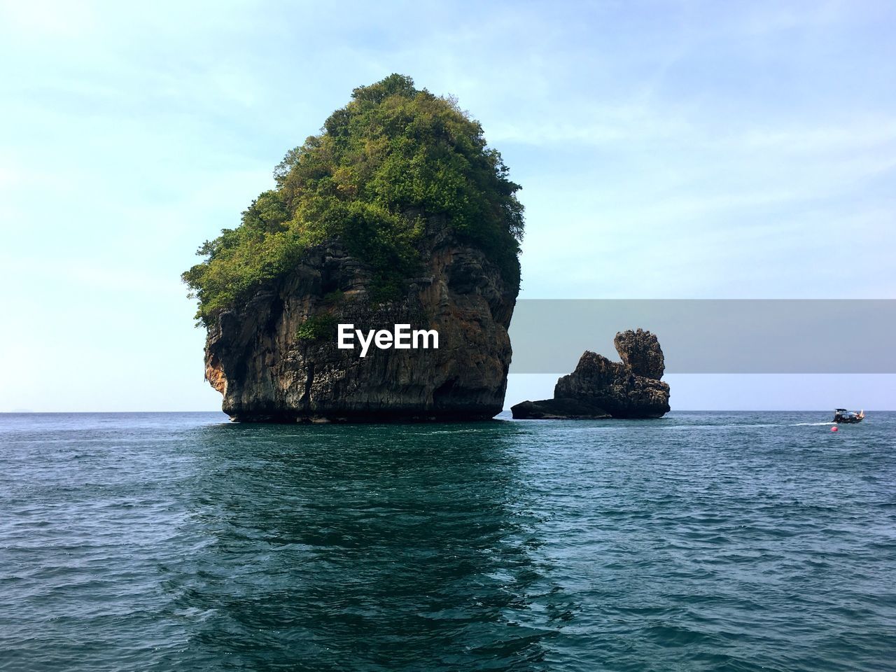 Rock formation by sea against sky