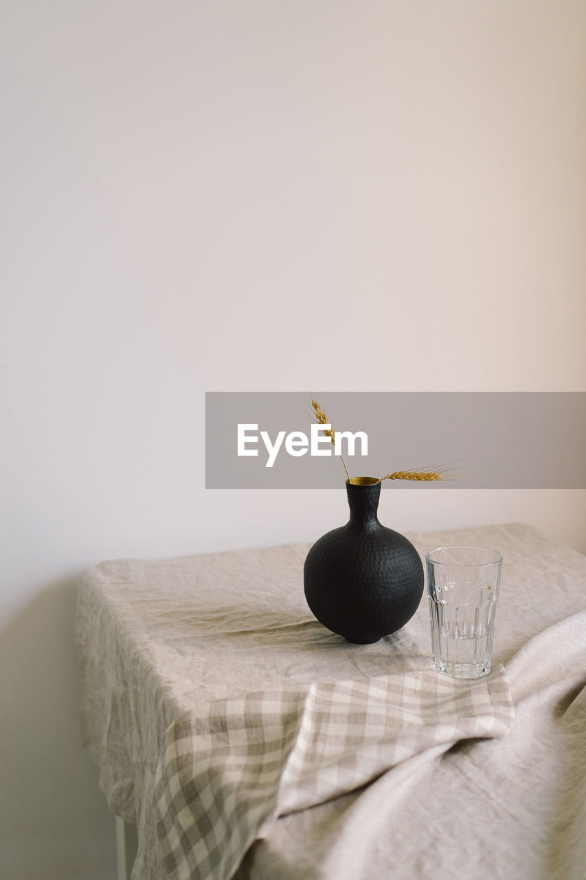 Modern dining table setting. a beautiful black vase with a linen napkin on the table.