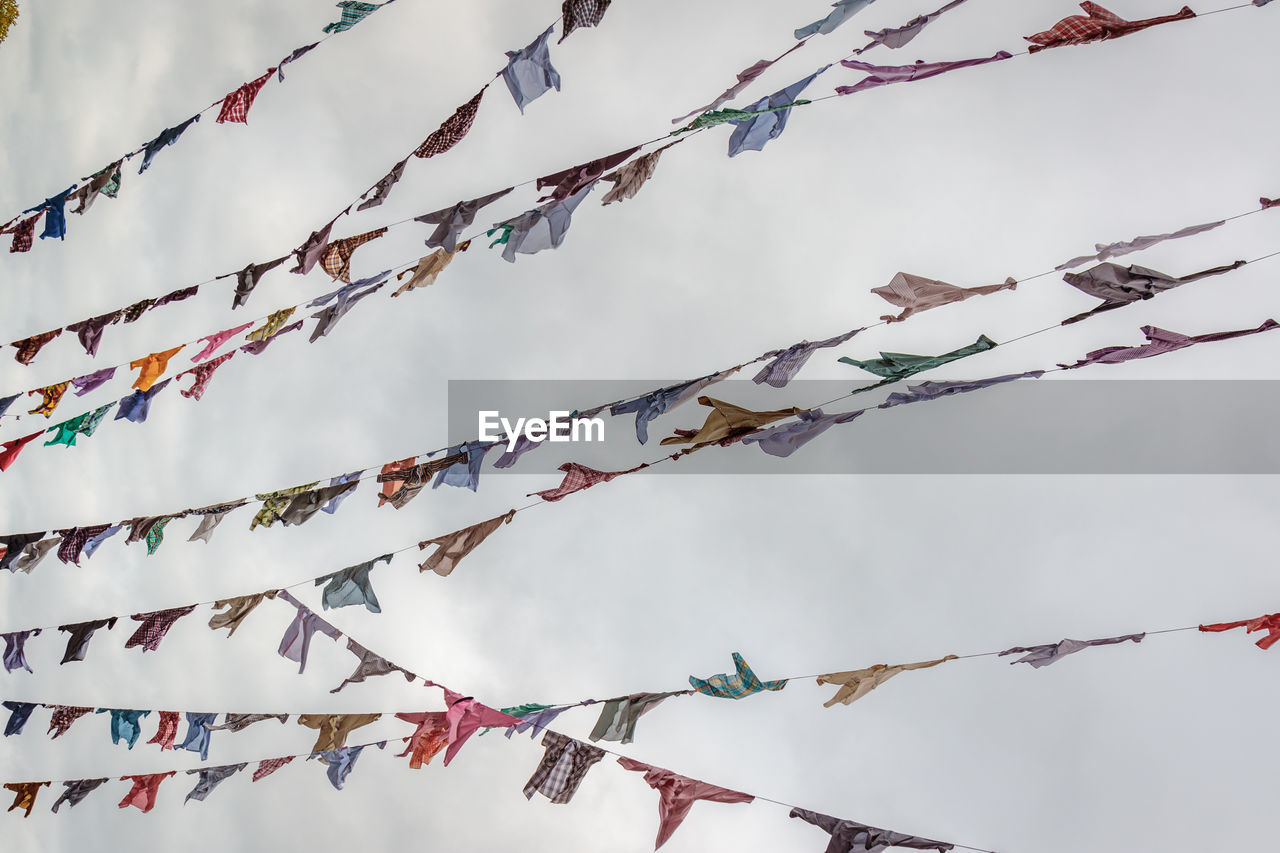 LOW ANGLE VIEW OF DECORATIONS HANGING ON BRANCH