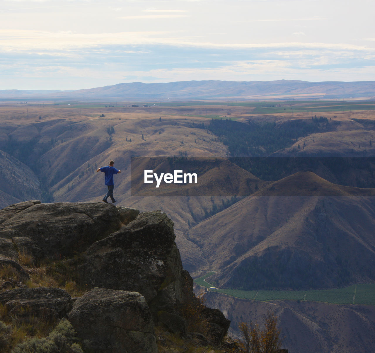 Rear view of man on mountain against sky