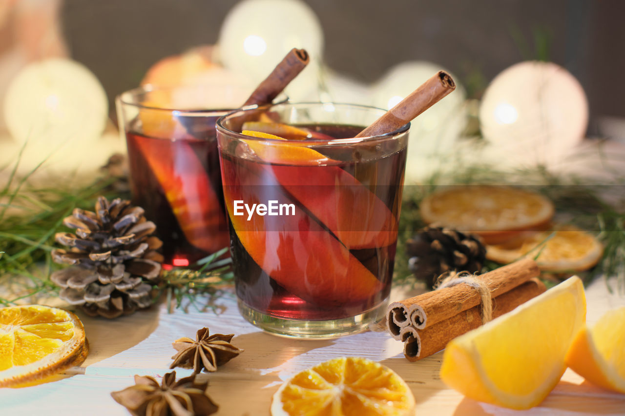 Glasses of mulled wine with cinnamon, anise  with decor and oranges. christmas holiday drinks.