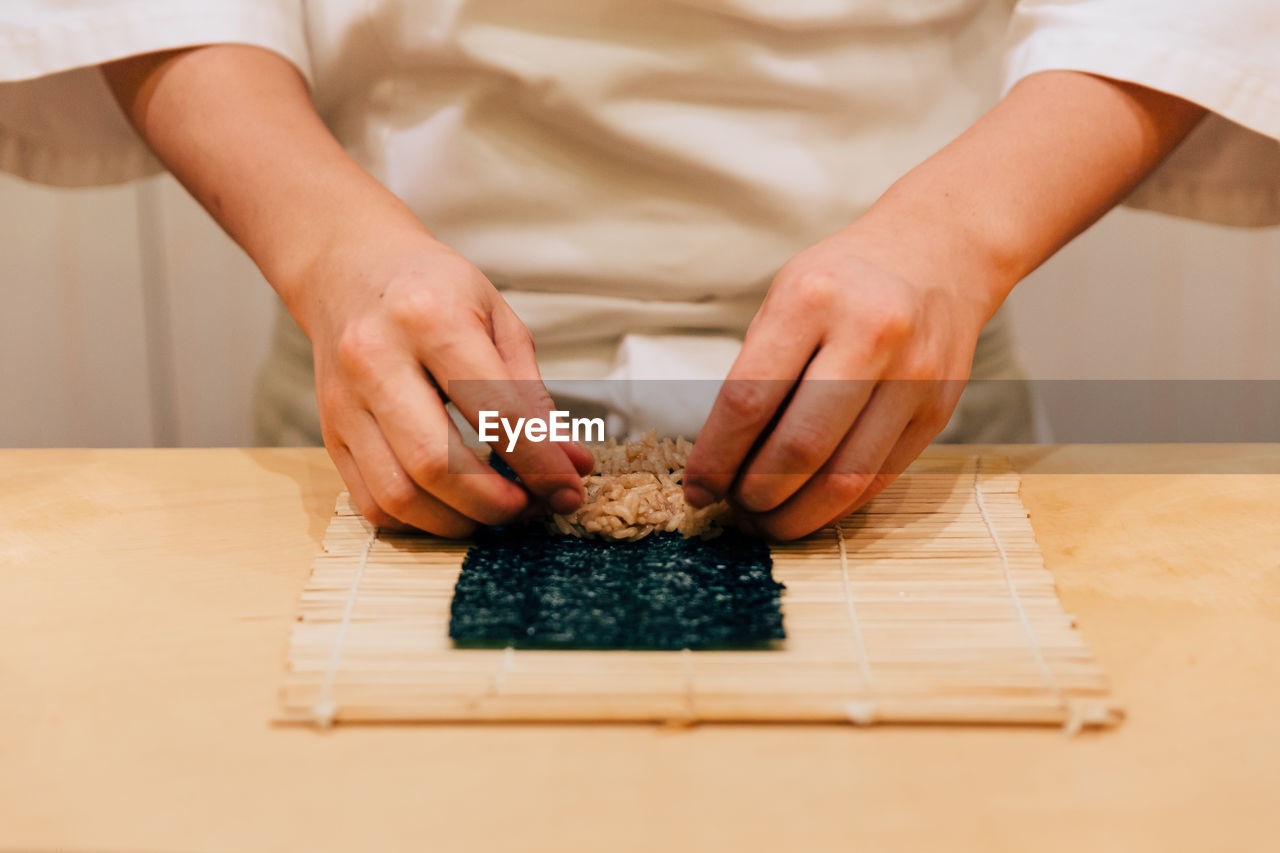 Midsection of man preparing food on table