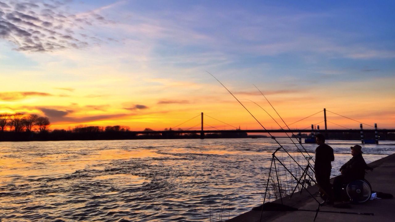 Silhouette of suspension bridge against sky during sunset