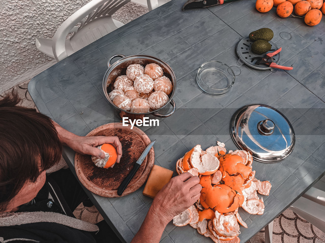 High angle view hands and oranges on table