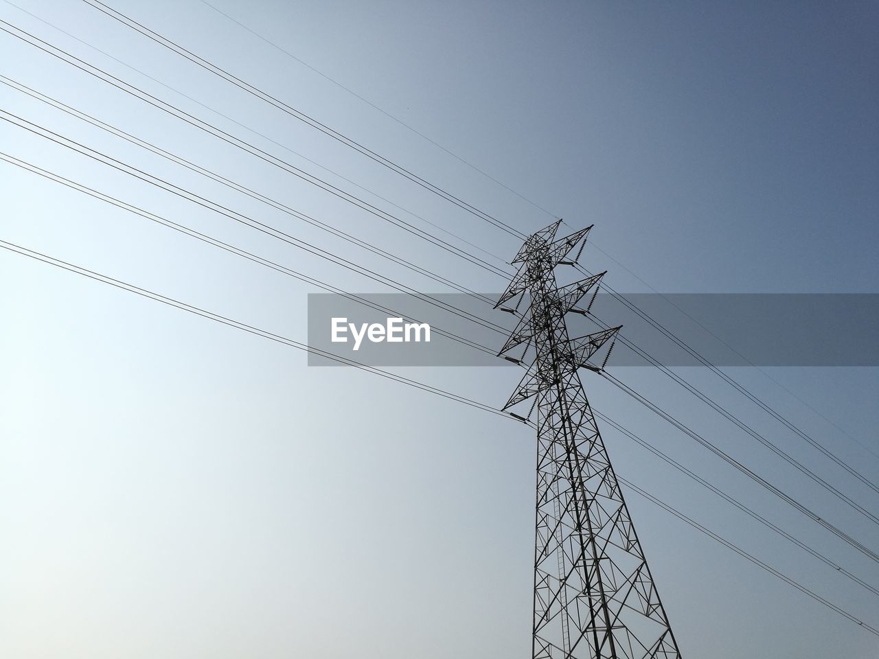 Low angle view of electricity pylon against clear sky